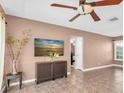Cozy living room with tile flooring, a ceiling fan, modern TV and a view into the next room at 1180 39Th N St, St Petersburg, FL 33713