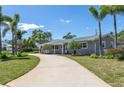 Inviting ranch-style home featuring a curved driveway, mature landscaping, and a neutral-toned facade at 1183 35Th Ne Ave, St Petersburg, FL 33704