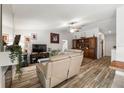 Bright living room with wood-look tile flooring, neutral walls, and a decorative hutch at 12815 Tallowood Dr, Riverview, FL 33579