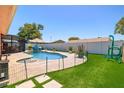 Backyard features a refreshing pool, lush artificial turf, and a privacy fence, creating a serene outdoor oasis at 13024 124Th Ave, Largo, FL 33774