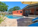 A view of the screened-in patio and outdoor pool, surrounded by a brick paver patio, perfect for outdoor entertaining at 13024 124Th Ave, Largo, FL 33774