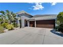 Gray two-story home featuring a three-car garage, well-kept lawn and attractive desert-style landscaping at 13622 Tonya Anne Dr, Riverview, FL 33579