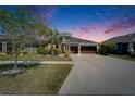 Well-manicured lawn with beautiful landscaping leading up to this gray, two-story home with a three-car garage at 13622 Tonya Anne Dr, Riverview, FL 33579