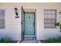 Inviting entryway showcasing a charming teal front door with modern hardware and a decorative light fixture at 13870 Oakwood Ln # 13870, Seminole, FL 33776