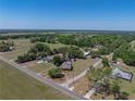 Aerial view of a home situated on expansive land surrounded by lush greenery and scenic countryside at 14721 Scharber Rd, Dade City, FL 33525