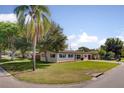 Spacious single-story home featuring a well-maintained lawn and mature trees at 1644 Scott St, Clearwater, FL 33755