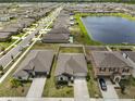 Expansive aerial view of a residential community showcasing numerous homes, green spaces, and a large central pond at 16665 Delia St, Wimauma, FL 33598