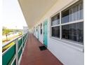 Long, outdoor condo hallway with multiple windows, a tile floor, and white walls at 1950 59Th N Ave # 208, St Petersburg, FL 33714