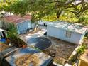 View of the fenced backyard with trampoline, storage shed, and mature trees at 3212 E Henry Ave, Tampa, FL 33610