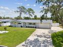 Well-maintained single-story home featuring a lush green lawn and a wide driveway leading to an attached garage at 4501 Huntington Ne St, St Petersburg, FL 33703
