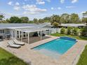 A backyard featuring a rectangular pool with a sun deck, covered patio, and well-maintained landscaping at 4501 Huntington Ne St, St Petersburg, FL 33703