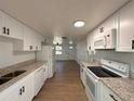 Bright kitchen featuring granite counters, white cabinets, and modern appliances at 4623 Irene Loop, New Port Richey, FL 34652