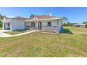 Inviting single-Gathering home featuring a covered front porch and attached garage at 7509 Hackamore Rd, Zephyrhills, FL 33541