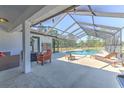 Relaxing screened-in pool area with outdoor furniture, perfect for entertaining guests at 7509 Hackamore Rd, Zephyrhills, FL 33541