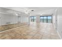 Spacious living area with tile flooring, floor to ceiling mirrors, and beautiful water views at 7520 Sunshine Skyway S Ln # 110, St Petersburg, FL 33711