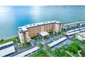 An aerial view reveals a condo complex with waterfront views, covered parking, and verdant landscaping at 9 Haig Pl # 510, Dunedin, FL 34698