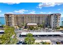 Exterior of the building featuring a covered parking area, well maintained landscaping, and waterfront views at 9 Haig Pl # 510, Dunedin, FL 34698