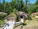 Charming single-story home featuring a well-maintained lawn, lush landscaping, and inviting curb appeal at 1135 Wyndham Lakes Dr, Odessa, FL 33556