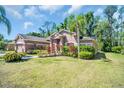 Well-manicured lawn with vibrant landscaping surrounds this lovely single-Gathering home and attached garage at 1135 Wyndham Lakes Dr, Odessa, FL 33556