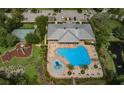 Aerial view of community pool, clubhouse, playground, and pond at 11833 Castine St, New Port Richey, FL 34654