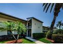 Condo exterior with mature palms and landscaping. The front entrance and private balcony offer curb appeal and outdoor living at 124 Nina Way # 24, Oldsmar, FL 34677