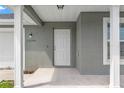 Inviting front entrance features a white door with sidelights and classic white pillars at 13193 Paxton Ave, Weeki Wachee, FL 34614