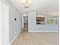 Open-concept living area with wood-look floors leading to carpet and an eat-in kitchen at 13193 Paxton Ave, Weeki Wachee, FL 34614