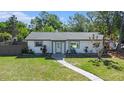 Inviting single-story home featuring a well-maintained lawn and inviting walkway under a bright sky at 1601 Paloma Ln, Dunedin, FL 34698