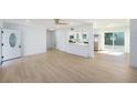 Bright, open-concept living room with modern flooring flowing seamlessly into a kitchen and dining area at 1601 Paloma Ln, Dunedin, FL 34698