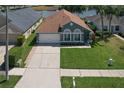 Traditional one-story home with verdant lawn, neutral paint and attached two car garage at 1624 Maximilian Dr, Wesley Chapel, FL 33543
