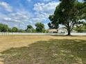 Expansive front yard with mature trees and a white picket fence lining the property at 17127 Brown Rd, Odessa, FL 33556
