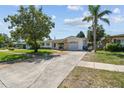 Charming single-story home with mature trees, well-maintained lawn, and an inviting curb appeal on a sunny day at 1751 Ashton Abbey Rd, Clearwater, FL 33755