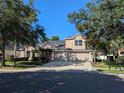 Beautiful two-story home with a three-car garage, lush landscaping, and a spacious driveway for multiple vehicles at 19116 Nature Palm Ln, Tampa, FL 33647
