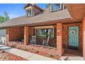 Charming brick home featuring a cozy front porch with rocking chairs and a welcoming blue front door with decorative wreath at 19254 Blount Rd, Lutz, FL 33558