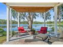 Covered patio with comfortable seating, a fire pit, and scenic lake views at 19254 Blount Rd, Lutz, FL 33558