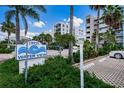 Entrance signage at Water View Condominiums, showcasing tropical landscaping and a well-maintained parking area at 19925 Gulf Blvd # 503, Indian Shores, FL 33785