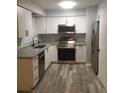 Well-lit kitchen with stainless steel appliances, ample storage, granite countertops, and durable flooring at 211 Harmony Ln, Brandon, FL 33511