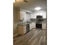 Modern kitchen with white cabinets, stainless steel appliances, granite countertops, and stylish flooring at 211 Harmony Ln, Brandon, FL 33511