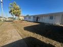 Exterior view of a single-story home with a small lawn and mature landscaping at 21811 Edgewater Dr, Port Charlotte, FL 33952