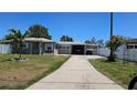 Inviting single-story home with a long driveway leading to a covered carport and manicured lawn at 2505 Minnehaha, Tampa, FL 33614