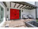 Inviting entrance featuring a striking red door, stylish lighting, and comfortable seating area at 2947 Cedar Trce, Tarpon Springs, FL 34688