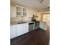 Modern kitchen with stainless steel appliances, white cabinetry, and beautiful dark wood flooring at 321 David Ave, Clearwater, FL 33759