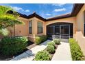 Inviting entrance with screened doors, manicured bushes, and a tiled walkway at 329 Seneca Falls Dr, Apollo Beach, FL 33572
