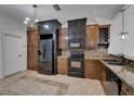 Kitchen featuring custom wood cabinets, black appliances, and tile backsplash at 329 Seneca Falls Dr, Apollo Beach, FL 33572