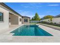 Relaxing backyard oasis featuring a sparkling pool and spa with elegant travertine tile at 33228 Kateland Dr, Wesley Chapel, FL 33545