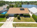 Aerial view of home with lush lawn, pool, and serene lake in neighborhood at 3330 Foxridge Cir, Tampa, FL 33618