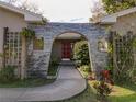 Inviting front entrance with a unique stone archway and lush landscaping at 5005 Puritan Rd, Tampa, FL 33617