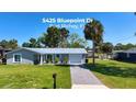 Charming single-story home with a neatly maintained lawn and a gray brick driveway at 5425 Bluepoint Dr, Port Richey, FL 34668