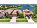 Beautiful waterfront single-Gathering home featuring lush landscaping and a tile roof at 5728 Sunset Falls Dr, Apollo Beach, FL 33572