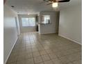 Open living room with tile flooring, a ceiling fan, and view into the kitchen at 6411 26Th W St, Bradenton, FL 34207